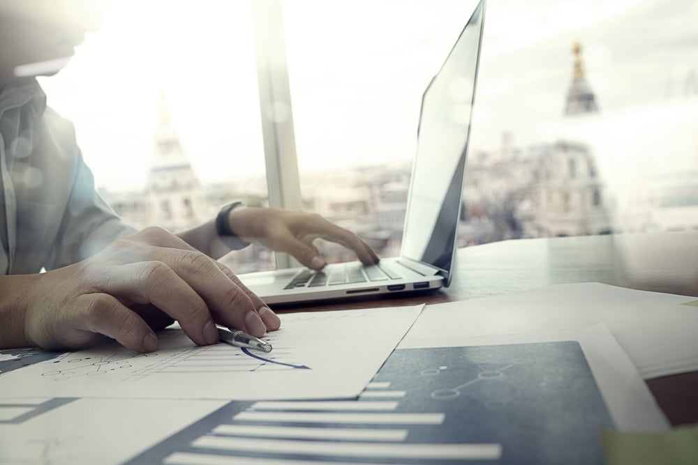 Closeup of laptop and documents to signify the modern workplace and agentless file encryption