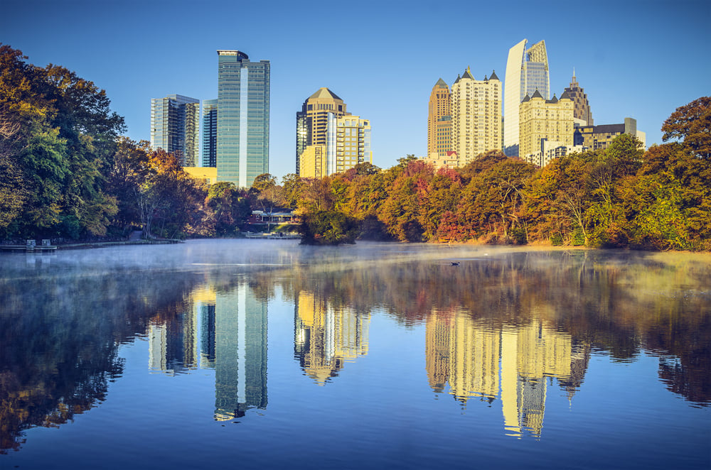 Image of the skyline of a city behind a lake and autumn trees to accompany our blog post for Cybersecurity Awareness Month, 