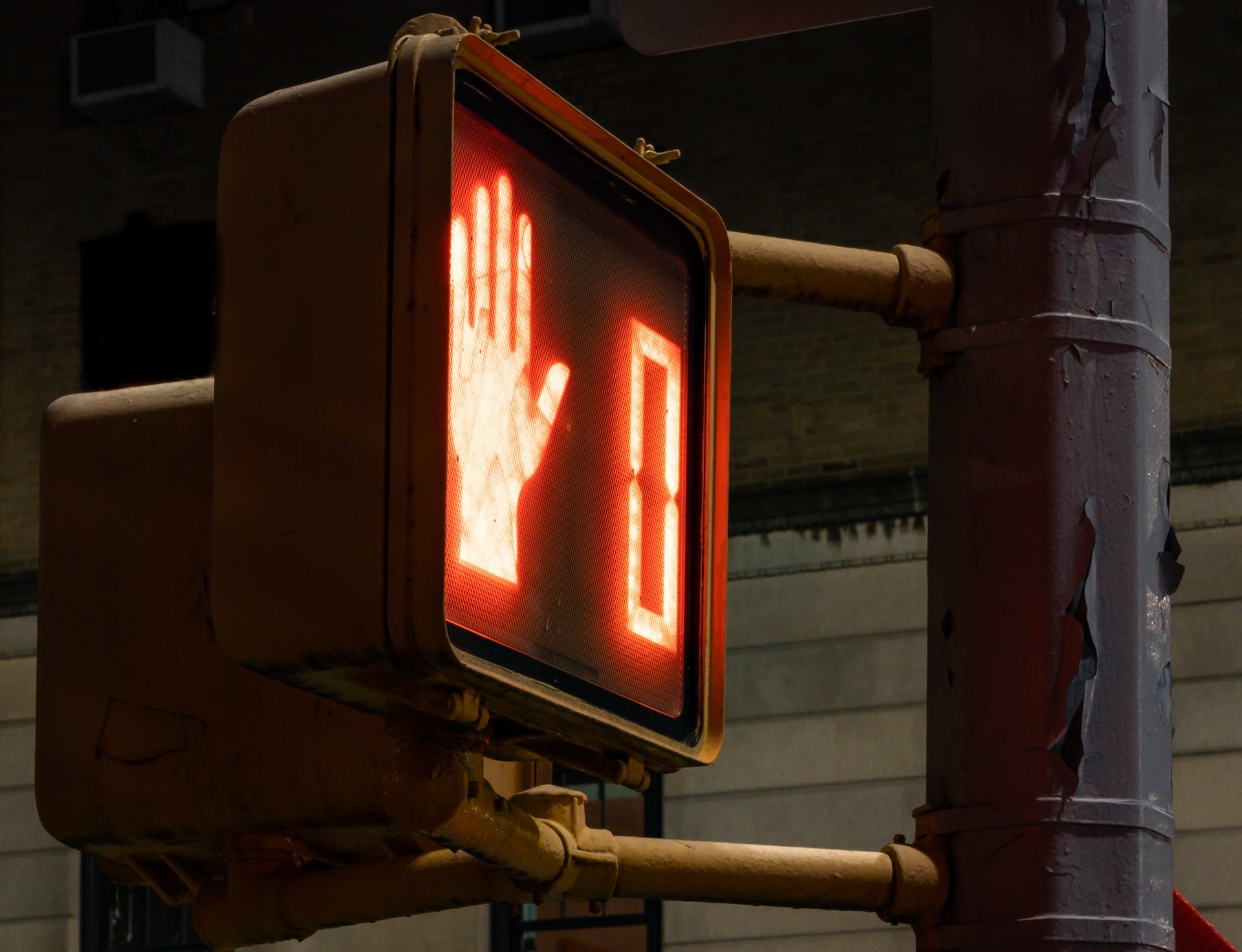 A crosswalk sign at red with a hand indicating 'do not cross'