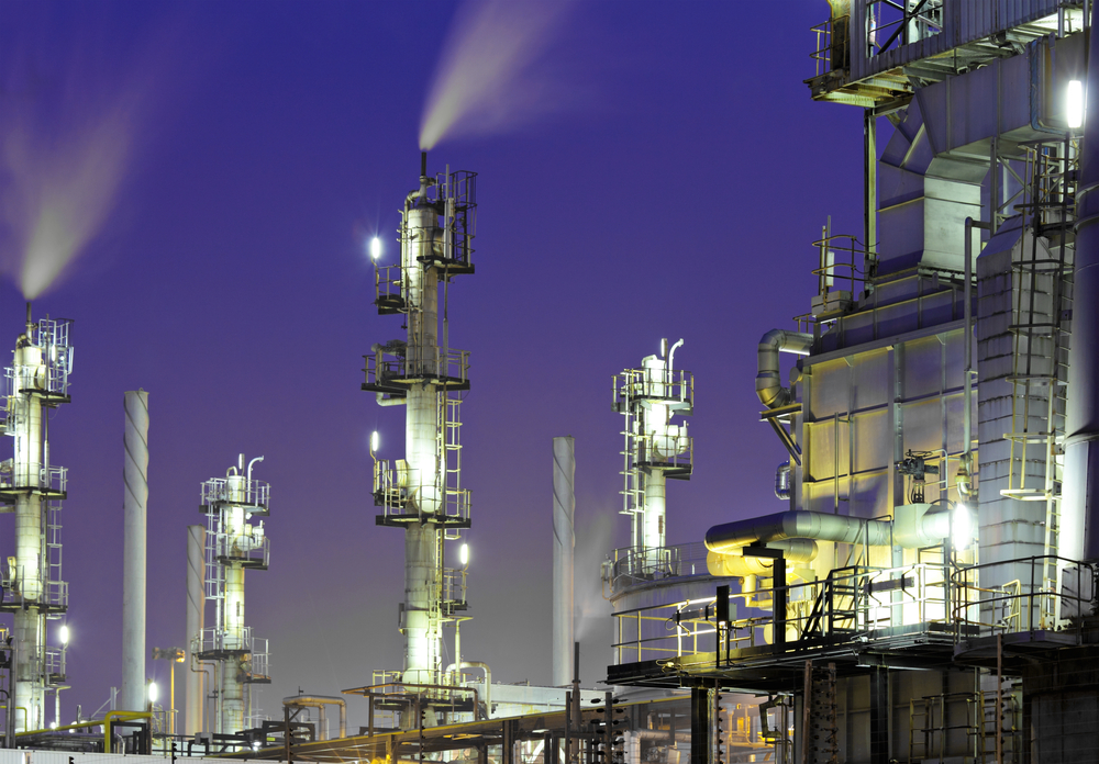 An oil refinery plant against a night sky to signify the current landscape of data security in manufacturing.