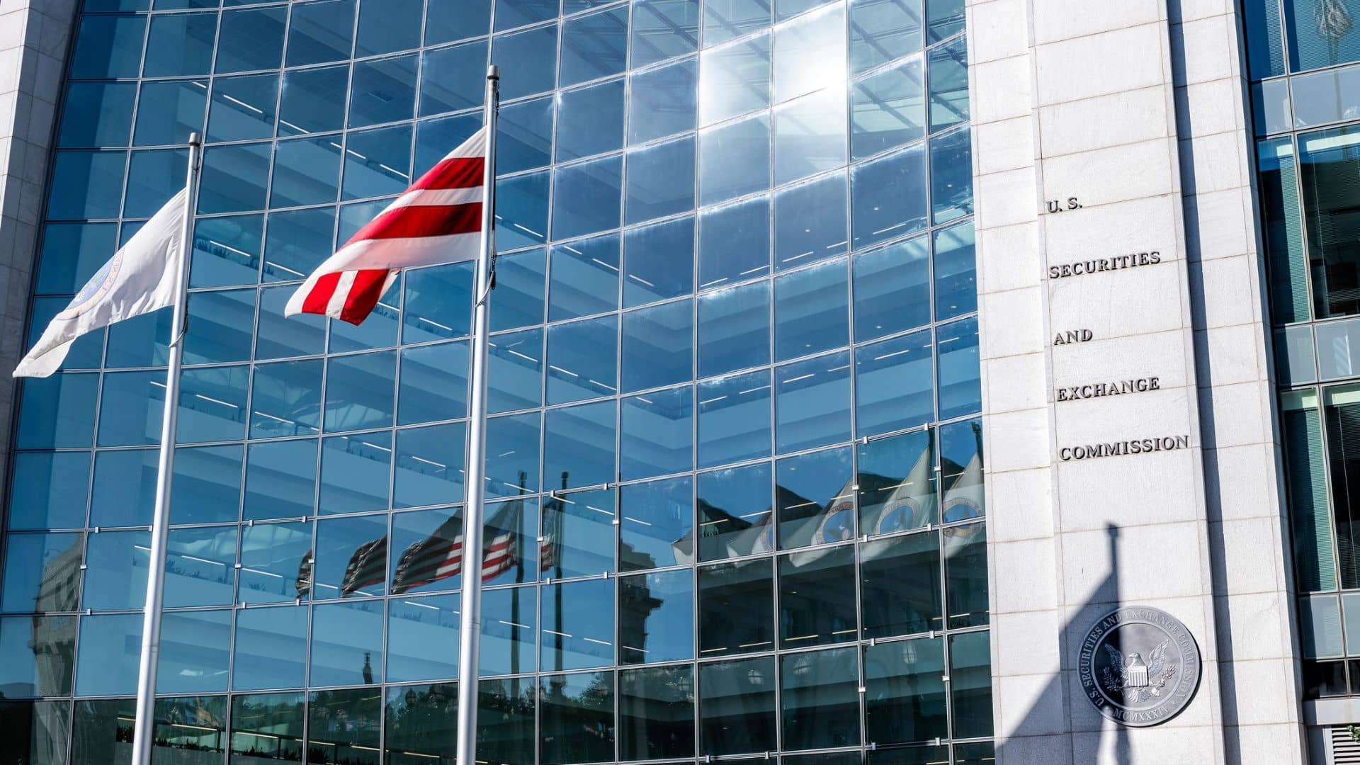 United States Securities and Exchange Commission SEC architecture closeup with modern building sign and logo with red flags by glass windows.